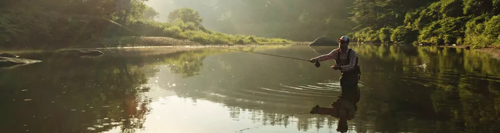 man fly fishing in stream