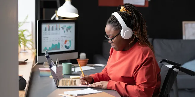 black woman in wheelchair with headphones on