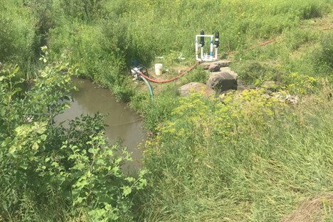 Pump withdrawing water from a small stream in Chittenden County.