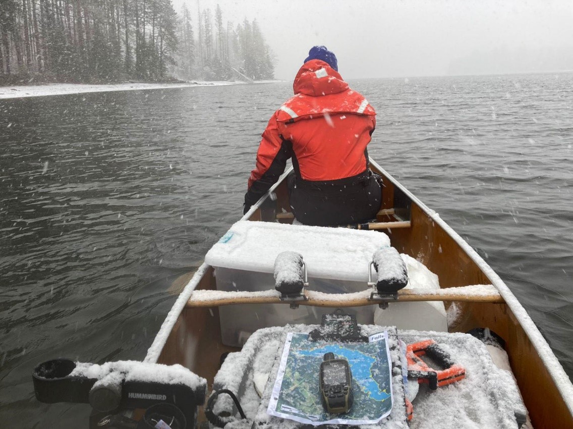 canoe on lake, paddlers bundled up for winter temperatures